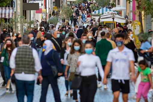 Athens, Greece, October 27, 2020 - crowd goes up and down a busy shopping street wearing a protective mask for covid19