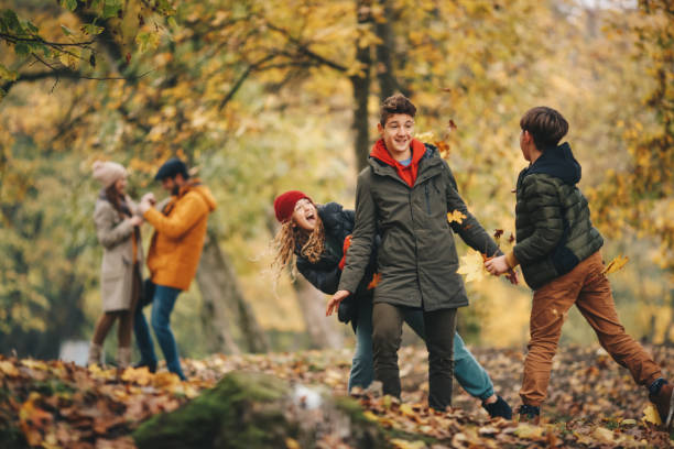 istock Children in forest, throwing fallen leaves at each other, playing. 1286144718