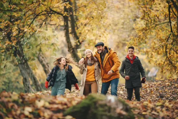 Photo of Happy family enjoys Autumn in forest.