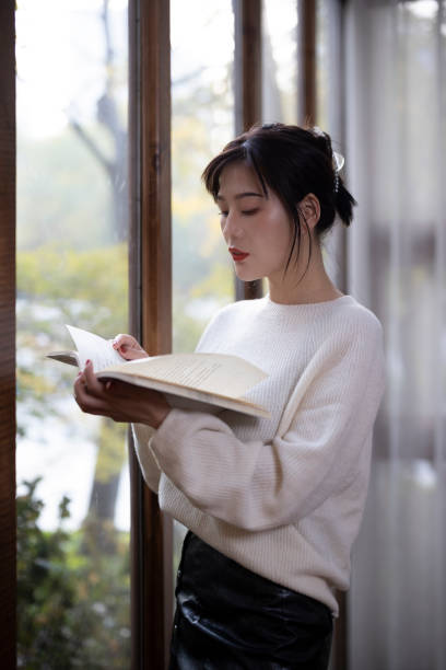 istock Asian girl reading by the window 1286145006
