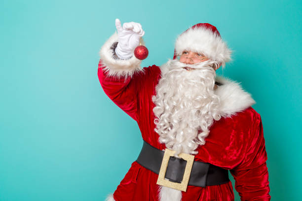 istock Santa holding Christmas tree ornament 1286145696