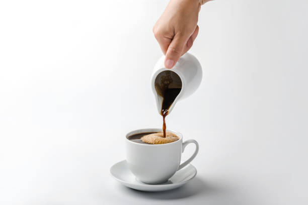 istock Pouring coffee on a cup isolated on white background 1286145734