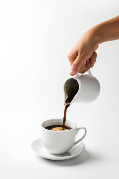 istock Pouring coffee on a cup isolated on white background 1286145752