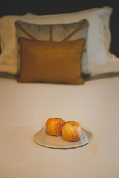 istock Welcome fruit, red apple put on white bed ready to eat in the hotel bedroom 1286147367
