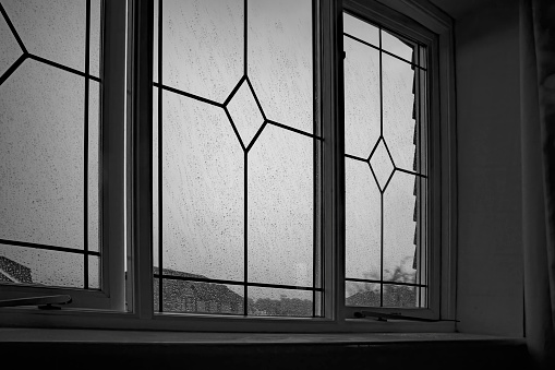 Wet and windy day viewed through a suburban window and expressing the depression and helplessness of unemployment and lock down.