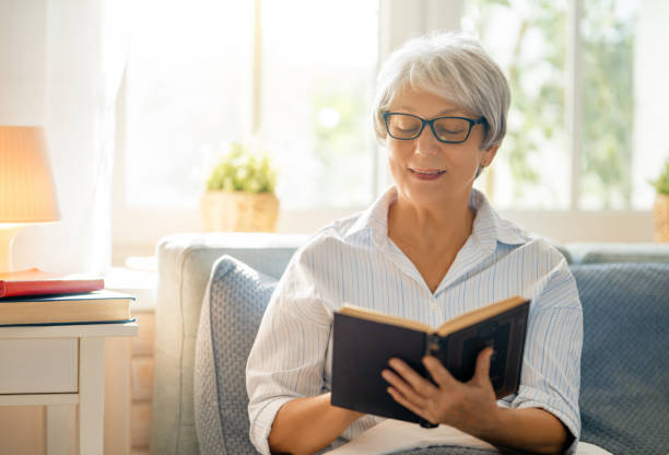istock senior woman is reading sitting on the bed 1286147708