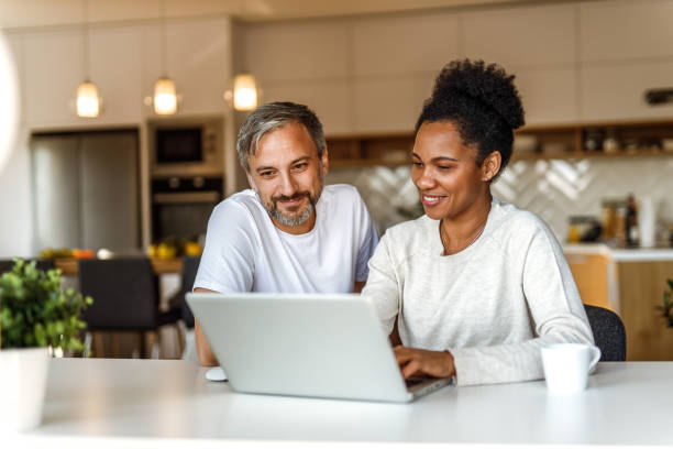 Enjoying at home together. Two adults using modern technology, searching something online. 40 49 years stock pictures, royalty-free photos & images