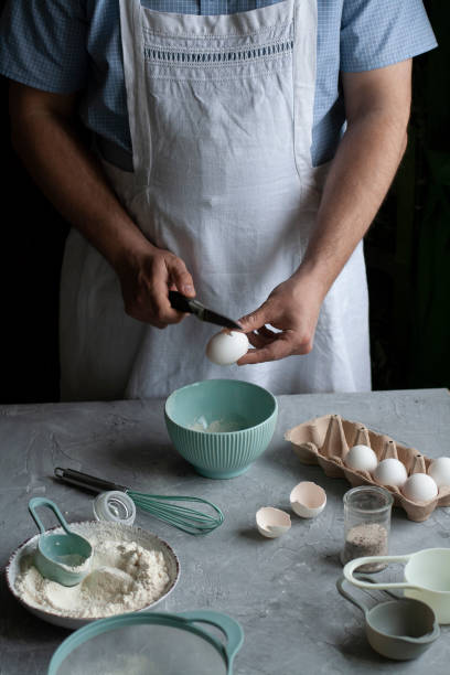 istock Making pancakes with chef. Chef at his workplace with cooking inventory and ingridients on a dark background. 1286149244