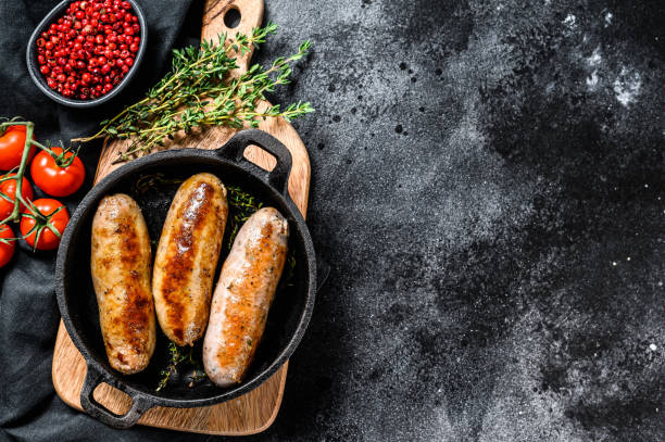 istock Pork sausages in a cast-iron pan. Black background. Top view. Copy space 1286151470