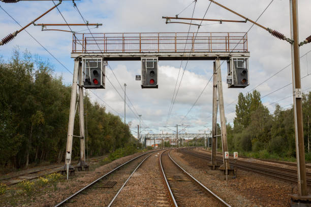 overhead gantry bahnsignale auf einer elektrifizierten bahnstrecke - overhead gantry sign stock-fotos und bilder