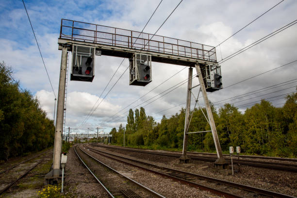 overhead gantry bahnsignale auf einer elektrifizierten bahnstrecke - overhead gantry sign stock-fotos und bilder