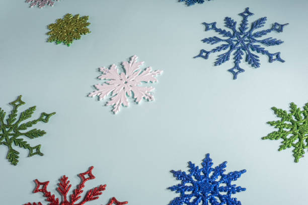 istock flatlay multicolored christmas snowflakes on a blue background. View from above 1286153225