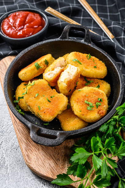istock Crispy fried chicken nuggets in a pan with ketchup and herbs. White background. Top view 1286153431