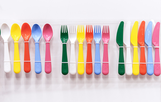 Multi-colored plastic cutlery for a children's party.