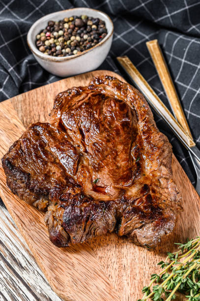 istock Grilled beef marbled steak. Chuck eye roll on the cutting Board. White background. Top view 1286157671