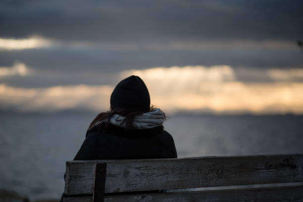 istock Woman on a bench watching the horizon 1286163456