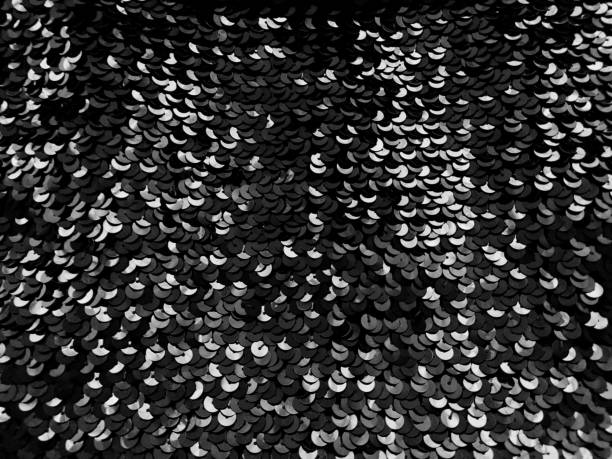istock Sequin fabric. Black sequins with white and gray sheen. Reflection of light on individual elements in a chaotic manner. Sewing or Christmas decorative background 1286168298