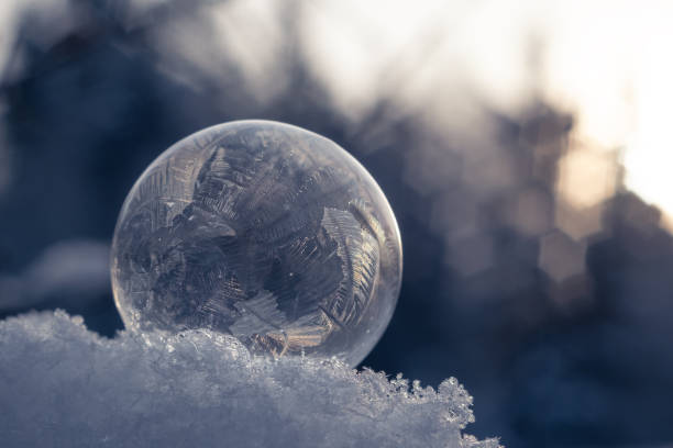 istock Frozen soap bubble with a beautiful pattern on the snow close-up on a blurry blue background.  Selective focus 1286168615