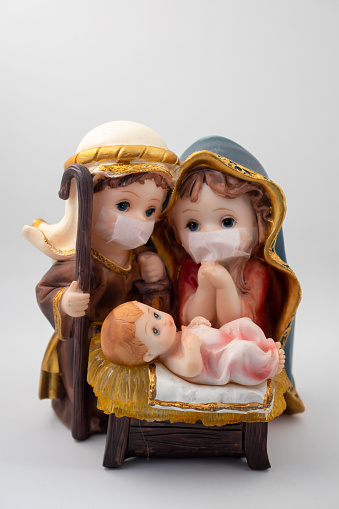 Paisaje de Navidad con delicadas figuras en la nueva normalidad del coronavirus o covid-19. José y María con chinstrap sobre fondo blanco. photo