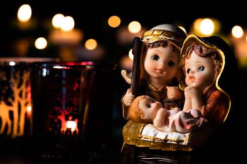 Paisaje de navidad con delicadas figuras recreando la fiesta cristiana. Escena clásica de Navidad iluminada por velas. Enfoque selectivo. photo