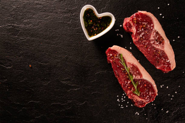 istock Two raw picanha steaks with spices on a dark background 1286174751