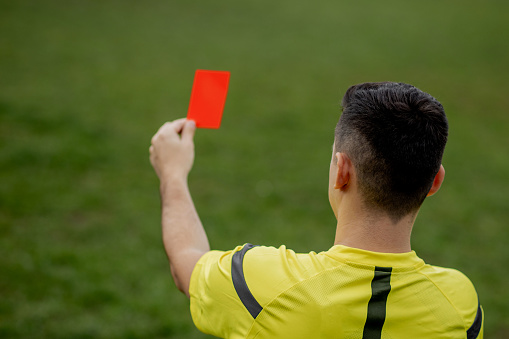 A football referee holding a yellow flag against the sky.  He is calling the penalty.   http://dl.dropbox.com/u/40117171/sport.jpg