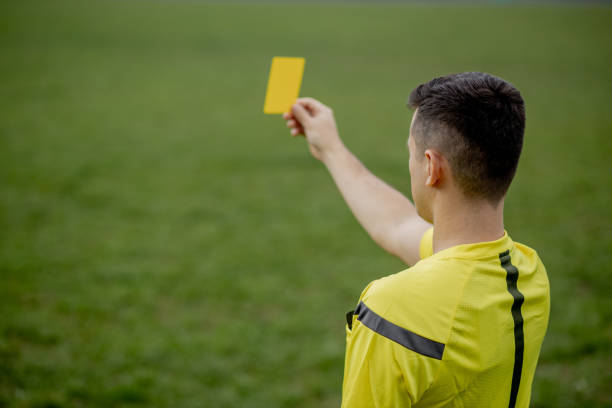 ゲーム中に不愉快なサッカーやサッカー選手にレッドカードを示す審判。スポーツの概念、ルール違反、論争の問題、克服の障害。 - yellow card ストックフォトと画像