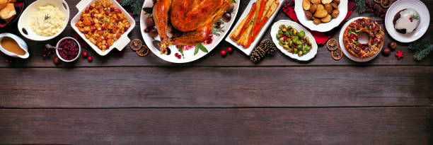 classic christmas turkey dinner. overhead view top border on a dark wood banner background with copy space. - parsnip vegetable food winter imagens e fotografias de stock