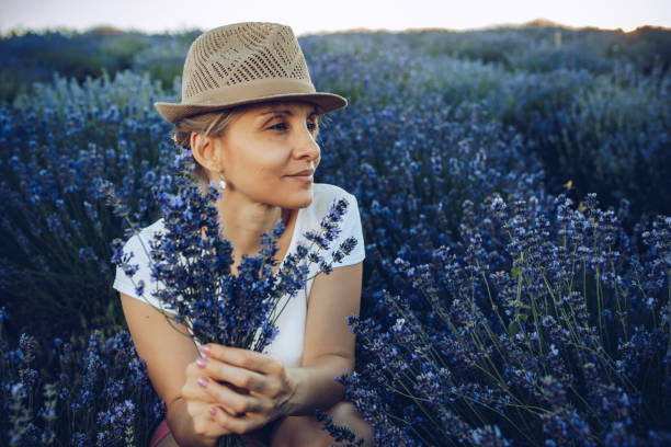 Mature blonde in the summer botanical garden, lavender fields