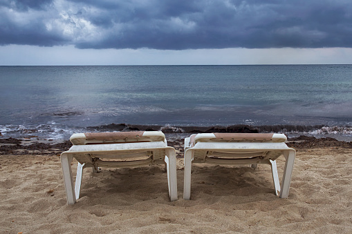 empty hammocks facing the sea on a cloudy day