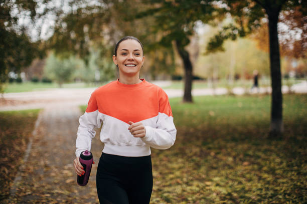istock Beautiful woman jogging in park 1286184179