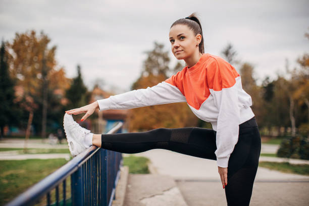 istock Beautiful young woman exercising in park 1286184414