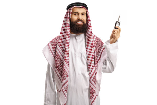 Saudi arab man holding car keys and smiling isolated on white background