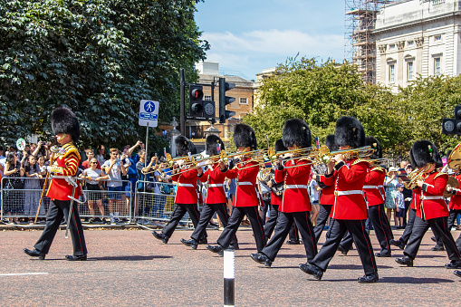 7 24 2019 London UK - British soldiers marching with trombones and trumpets during Changing of the Guard with tourists crowded at side of street watching. selective focus