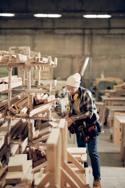 istock Woman stacking wood planks at the workshop 1286188821