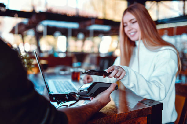 istock Female Freelancer Paying For Tea With Smartphone In Restaurant 1286188850