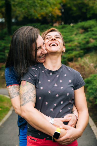 istock Laughing middle aged lesbian couple hugging outdoor 1286189332