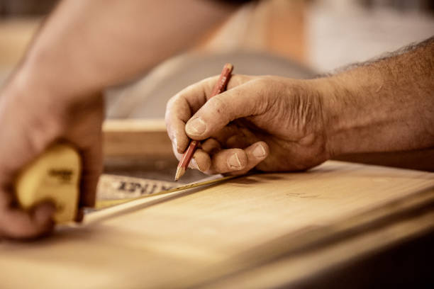 Hands of Carpenter Using Tape Measure To Mark a Plank