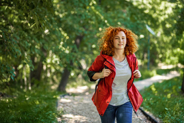 Woman with red raincoat walking in nature