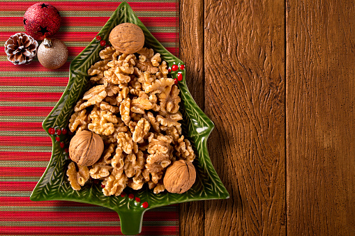 Walnuts in a Christmas Tree Pot on a wood background. Top View