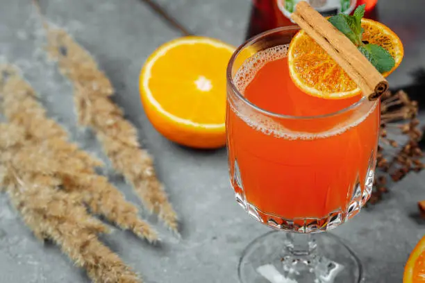 Warming winter cocktail with aperol. Hot aperol. Cocktail For New Years and Christmas. Christmas winter cocktail with Spritz martini pineapple juice and spices.