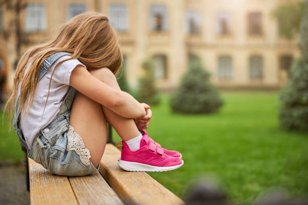 istock Sad child with family problem hiding face in the park 1286193968