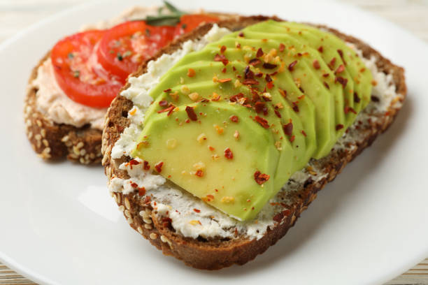 istock Tasty toasts with avocado and tomato on white background 1286203649