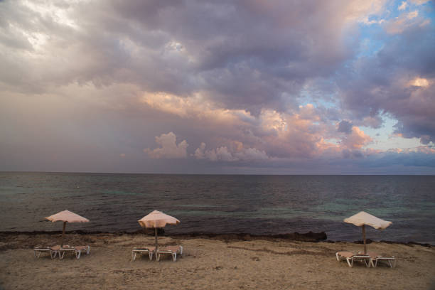 umbrellas and hammocks on the beach, empty due to bad weather