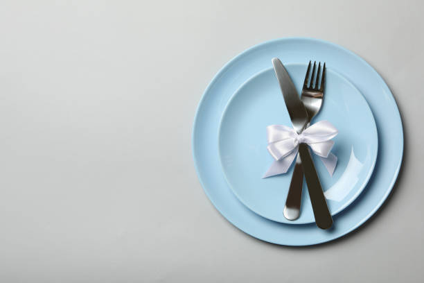 istock Plates with cutlery and bow on white background, top view 1286203973
