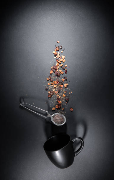 Composition of fruit tea cup and infuser - strainer. Flat lay isolated on gray black background. Blank free space for your advertising or text