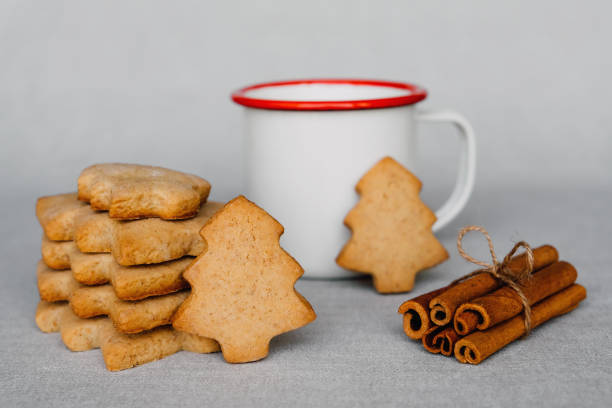 pile de délicieux biscuits faits maison en forme d’arbre de noël et tasse de boisson chaude. - cookie christmas shortbread christmas tree photos et images de collection