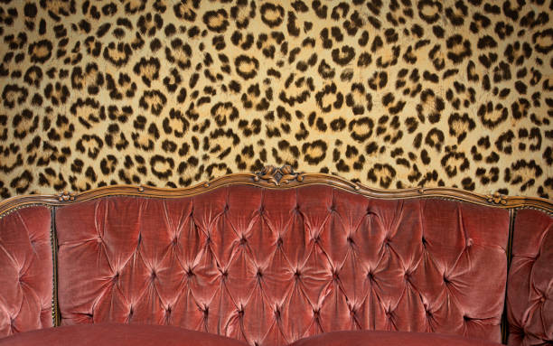 istock Modern fashionable stylish pink sofa with carriage stitch, buttons and leopard pattern wall background texture, Modern design space for text, copy space 1286209081