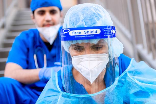 istock Serious, overworked, health care workers sitting looking down very sad 1286210732
