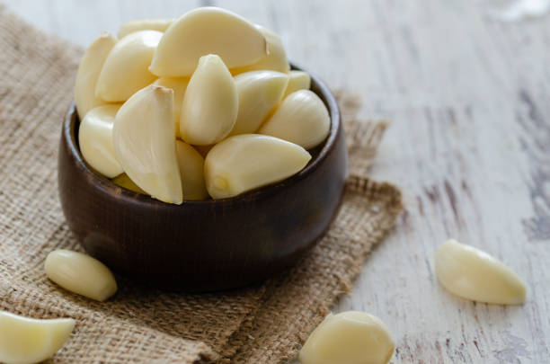 Peeled fresh garlic Close up of  garlic on the kitchen table. peeled stock pictures, royalty-free photos & images